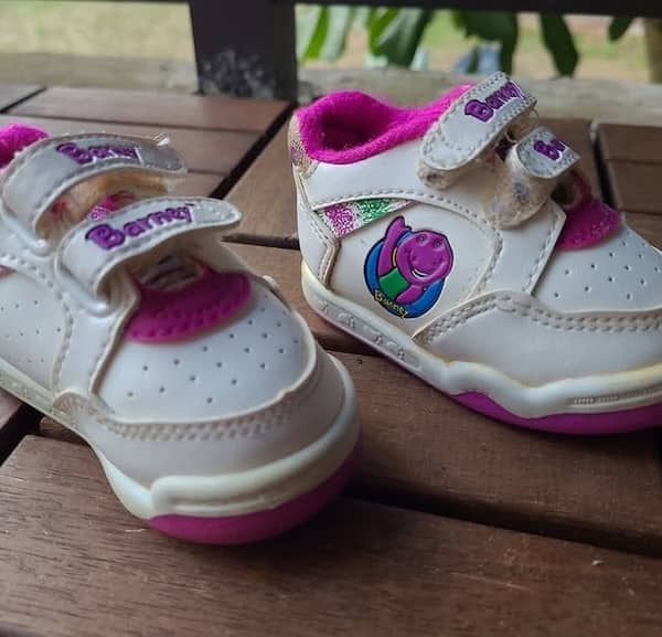 White and pink baby sneakers featuring Barney the dinosaur character art.