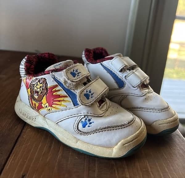 Lion King sneakers with paw print velcro straps and character art.