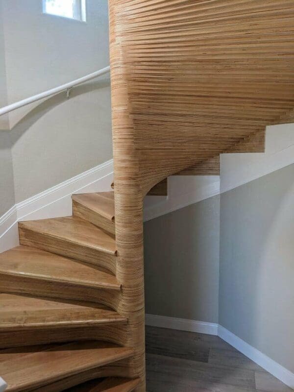 Stacked plywood spiral staircase showcasing exposed edge grain. An example of amazing woodworking adding modern home design.
