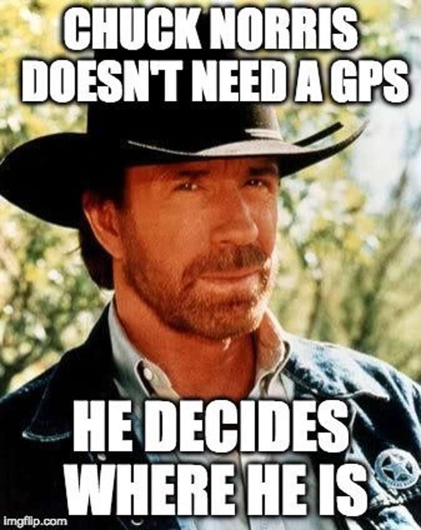 Chuck Norris in his iconic Walker, Texas Ranger cowboy hat and denim. The meme asserts he doesn't need a GPS because he simply "decides where he is."