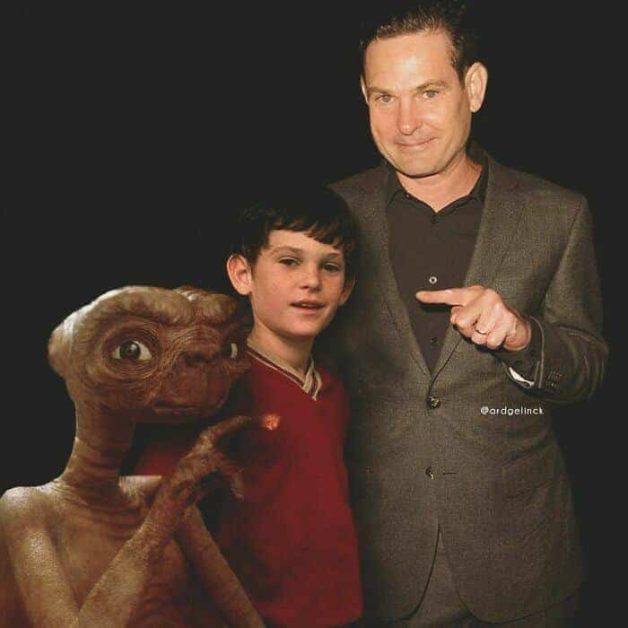 Henry Thomas pointing at his younger self and E.T. the Extra-Terrestrial.