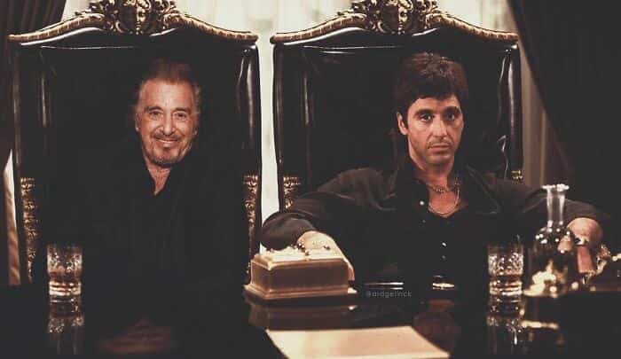 Al Pacino sitting at a table with his Scarface character Tony Montana.
