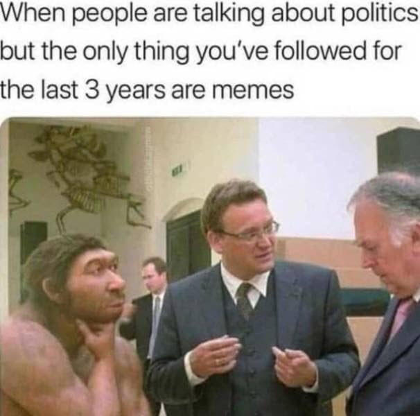 classic meme using a photo of a museum's Neanderthal exhibit looking suspiciously at two men in suits. The text reads: "When people are talking about politics but the only thing you’ve followed for the last 3 years are memes."