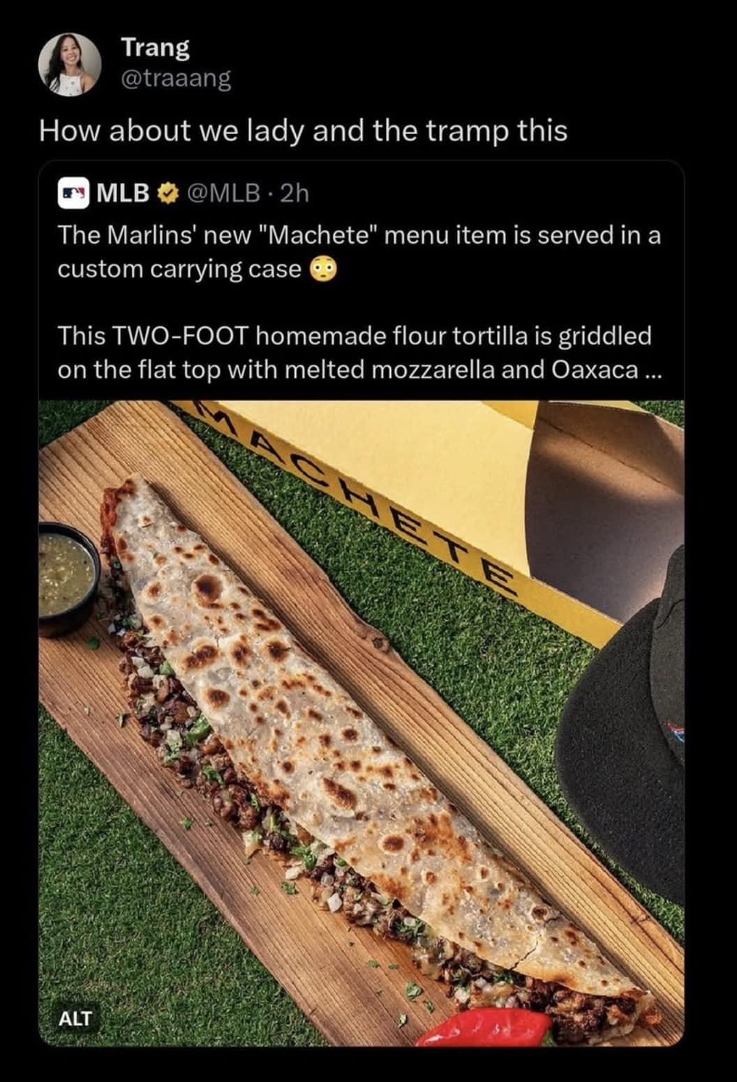 food-based classic meme quote-tweeting a photo of a "Machete"—a two-foot-long quesadilla served at Marlins games. Trang (@traaang) captions the absurd menu item: "How about we lady and the tramp this."