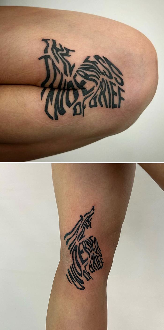 "The wilderness of grief" text tattoo that warps and folds into a dense black shape.