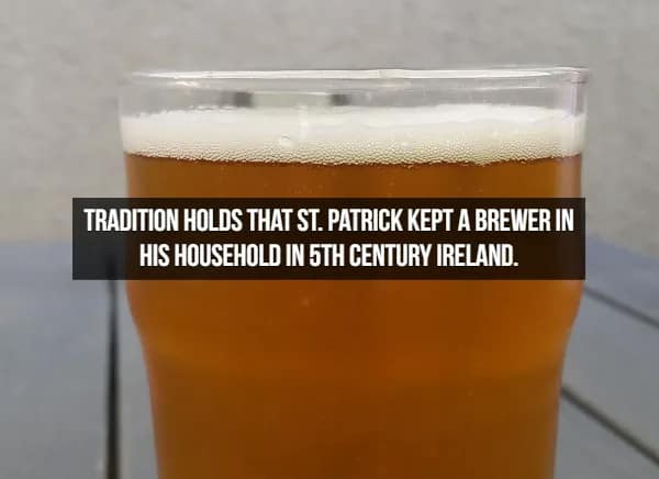 A tall glass of amber ale catching the light, accompanied by an Irish fact about beer: tradition states that St. Patrick himself kept a dedicated brewer in his household during the 5th century.