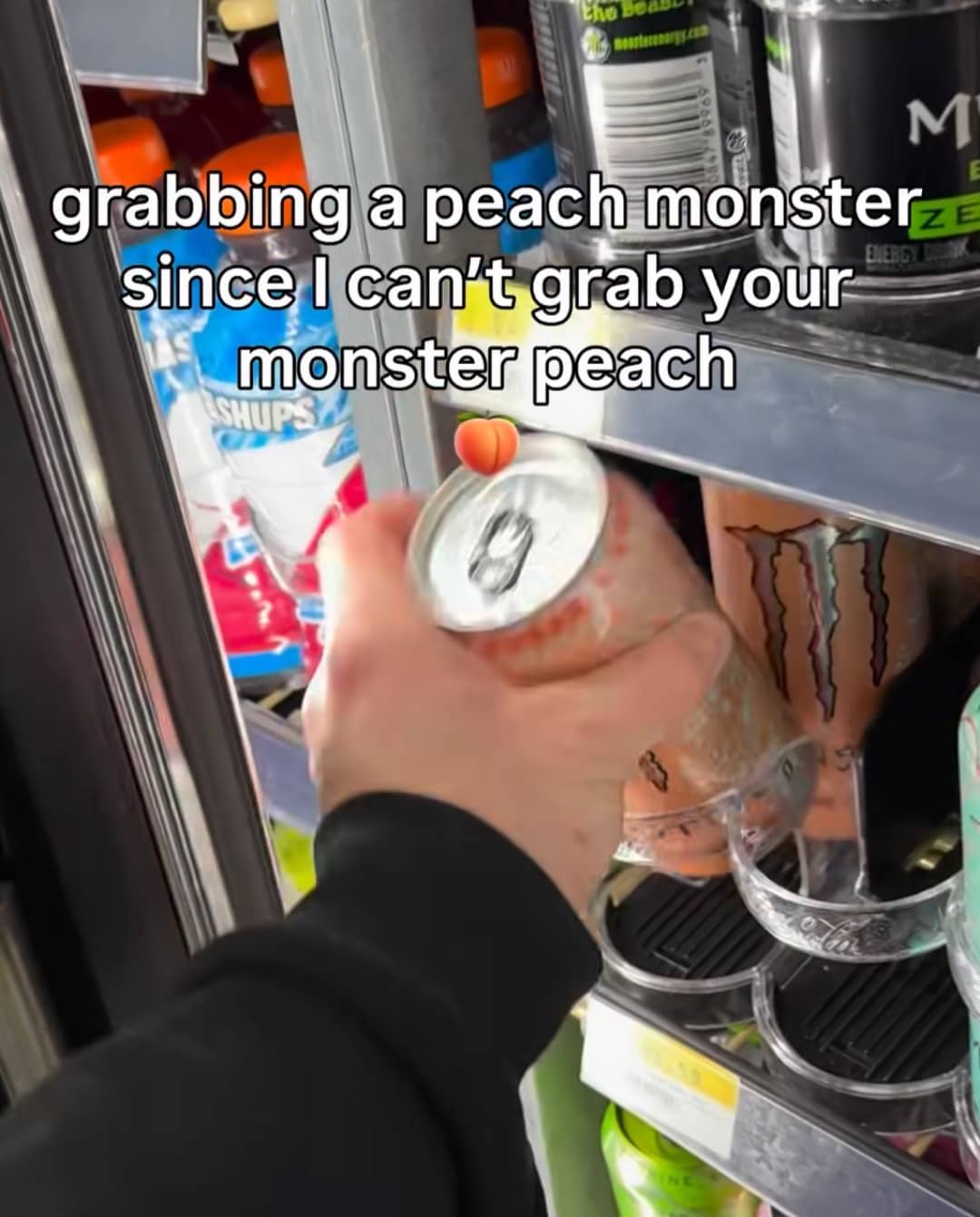 Hand reaching for a Peach Monster Energy drink in a cooler with a suggestive romantic caption.