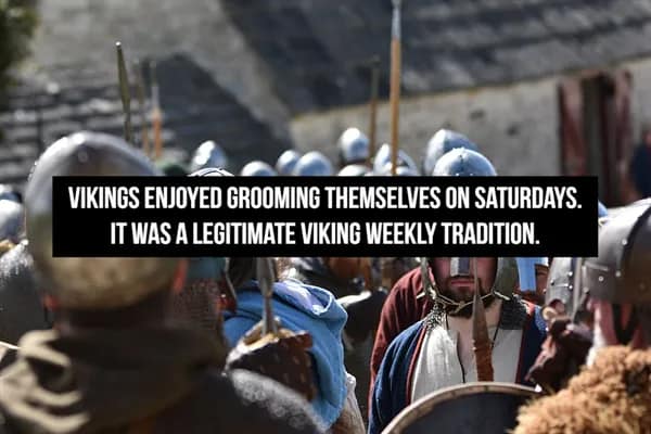 group of Viking reenactors in full combat gear and chainmail, sharing the historical fact that Saturdays were dedicated "grooming days" in Viking culture, making it a legitimate and scheduled weekly tradition.
