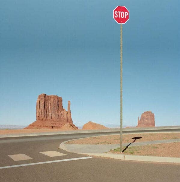 A creepy liminal space desert landscape featuring an unusually tall stop sign.
