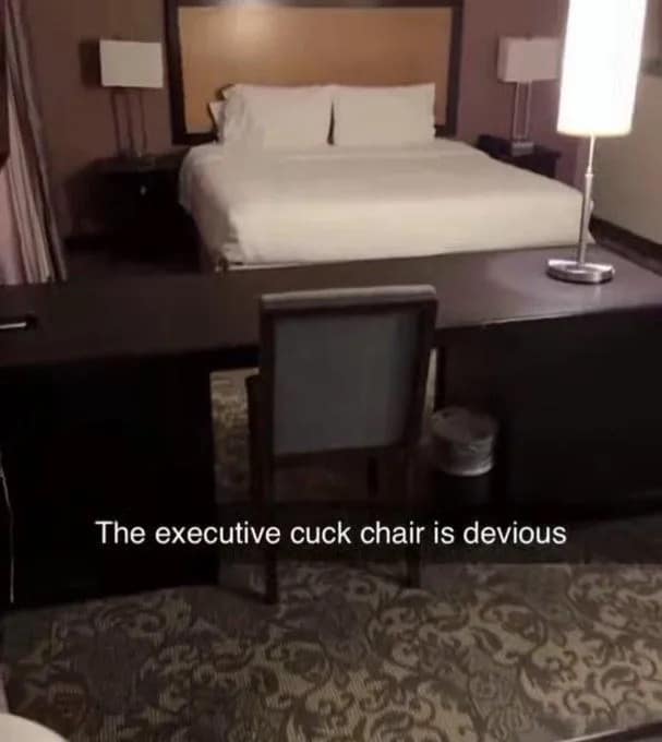 A cursed addition to this meme dump showing a hotel room layout where the executive desk and chair are placed directly at the foot of the bed, facing it. The caption reads, "The executive cuck chair is devious."