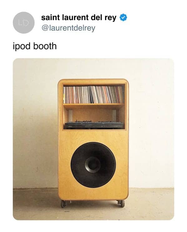 A wooden iPod booth featuring a vinyl record shelf, a mixing deck, and a large speaker.