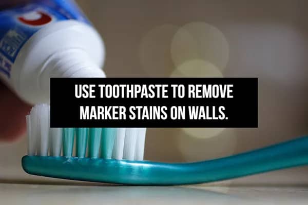 Toothpaste being applied to a brush with text explaining how it removes marker stains from walls.