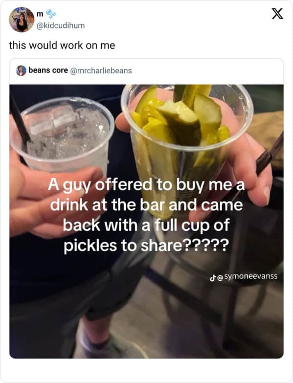 Photo of a plastic cup filled with pickles offered as a drink at a bar.